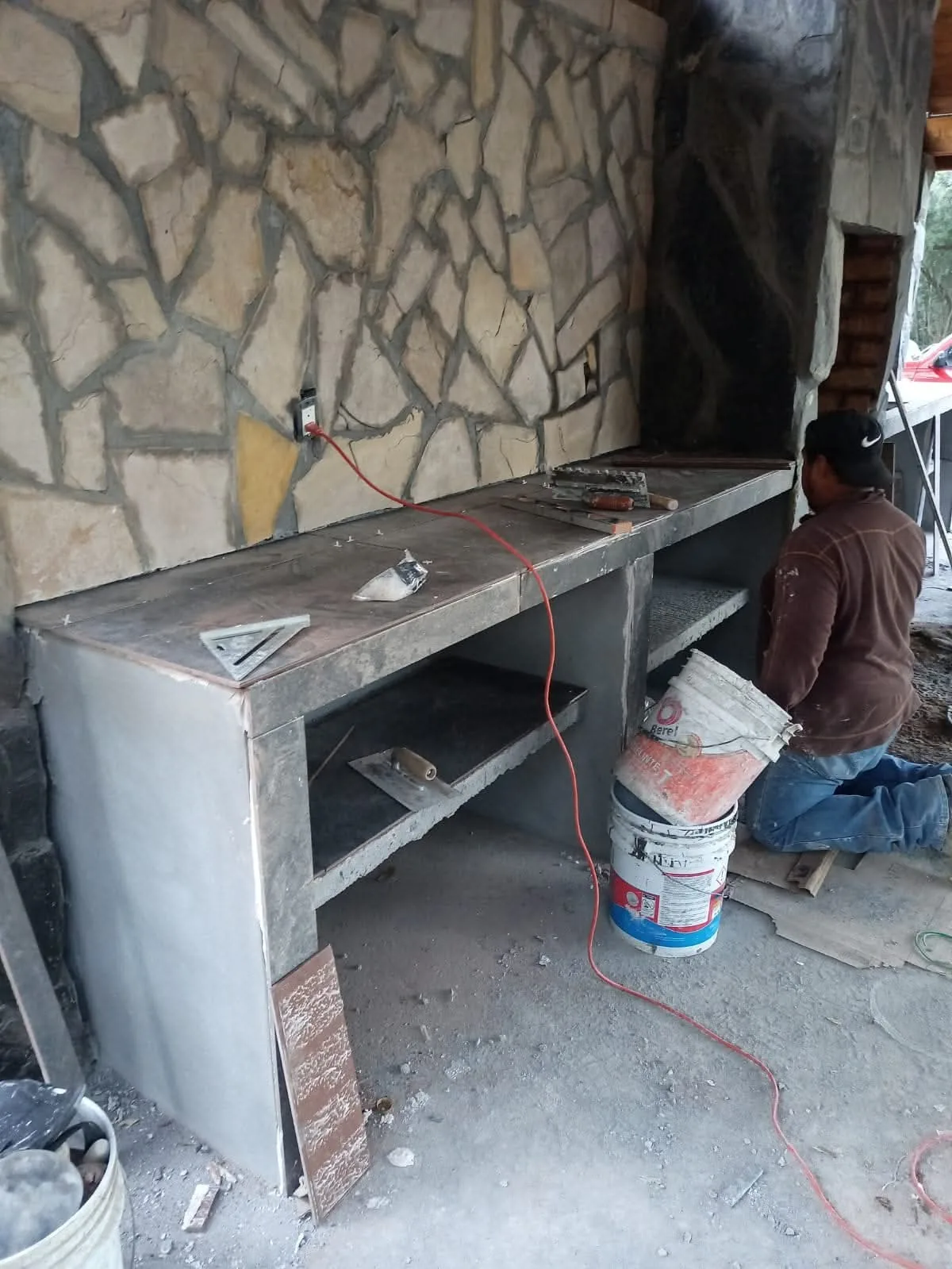 Área social con barra y acabado en piedra en proceso